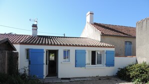 A small white building with blue shutters, a tiled roof, and a chimney. - Renovated traditional fisherman's cottage 250 m from the beach (L'Épine)