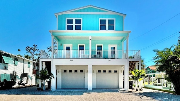 A two-story house with a balcony and two garages.