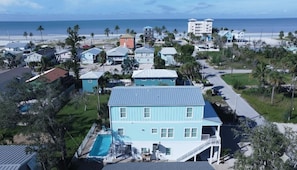 Un quartier résidentiel situé sur la côte, avec des maisons, une piscine et une vue sur l’océan.