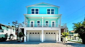 Een huis met twee verdiepingen, een balkon en twee garages.
