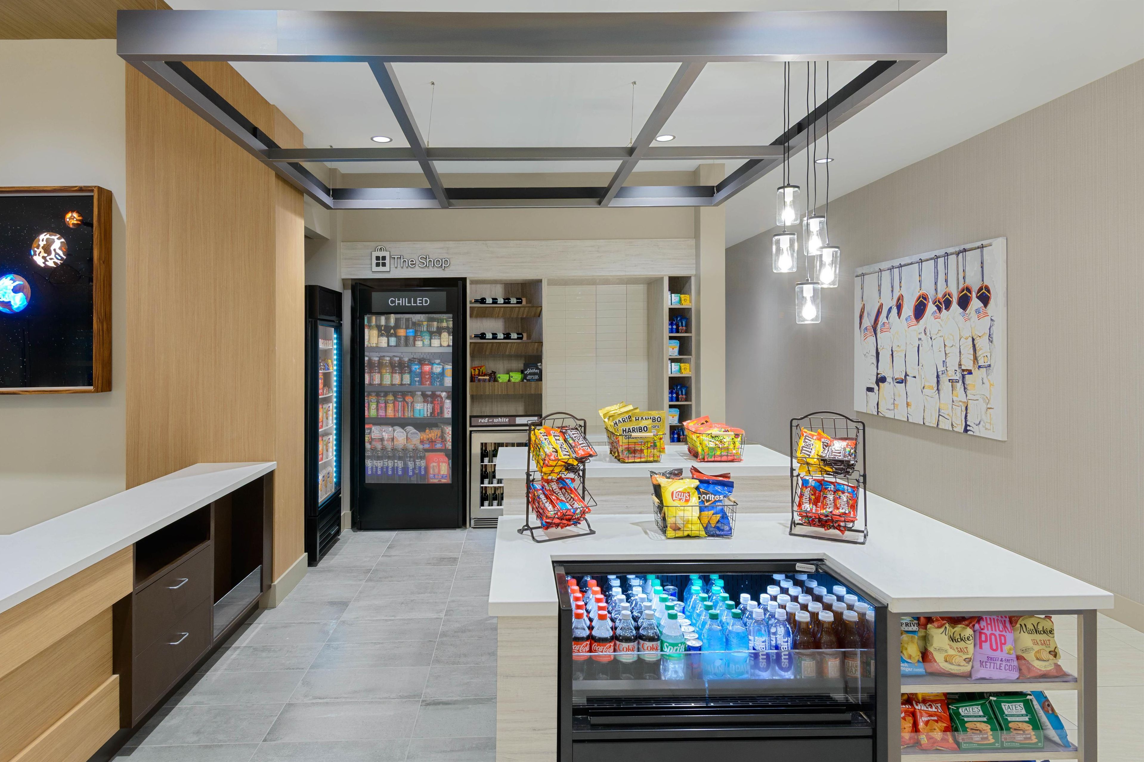A modern retail area with a refrigerated display, snack shelves, and a beverage cooler.