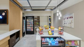 A modern retail area with a refrigerated display, snack shelves, and a beverage cooler.