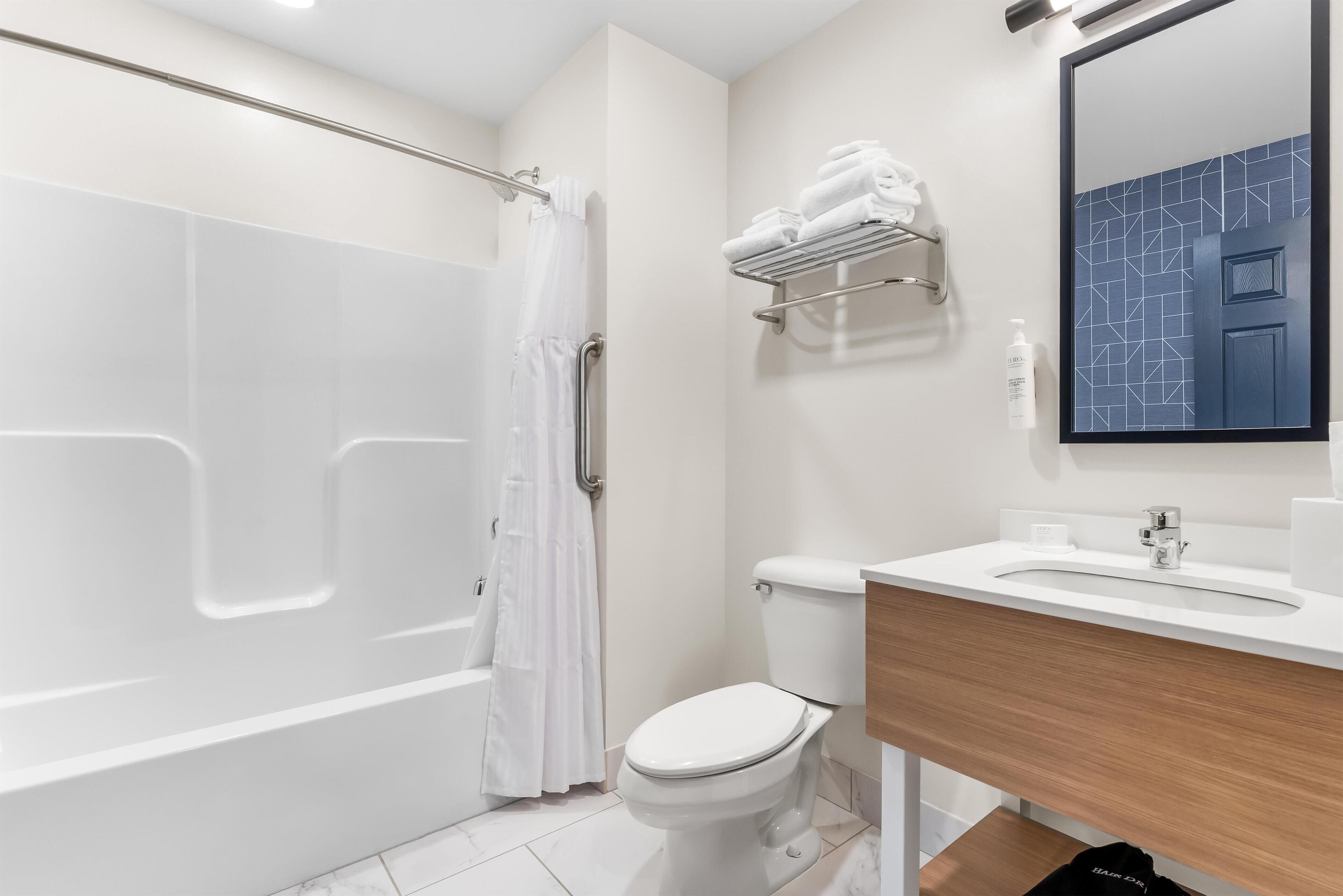 A modern bathroom with a bathtub, toilet, and sink.