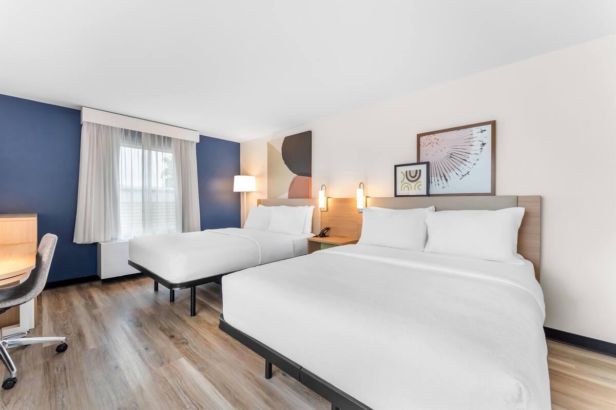 Quarto, 2 camas Queen | Ferros/tábuas de passar roupa, Wi-Fi de cortesia, roupa de cama