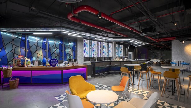 Un área de bar moderna con mostrador, asientos y piso estampado.