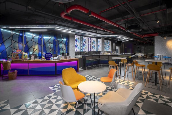 Un área de bar moderna con mostrador, asientos y piso estampado.