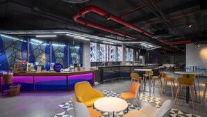 A modern bar area with a counter, seating, and a patterned floor. - Tru By Hilton Da Nang City Centre (Da Nang)