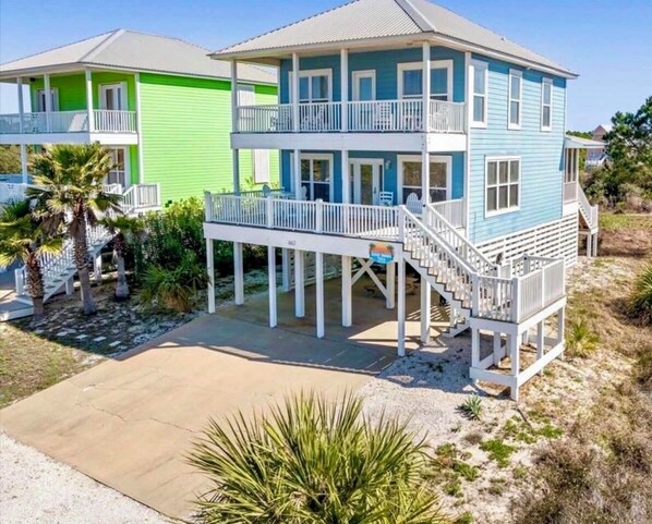A two-story house with a balcony, a covered porch, and a staircase leading to the upper level.