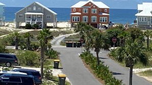 A coastal road with houses, palm trees, and a stop sign. - 4BR Fort Morgan: Stunning Gulf Views, Across From New Pool, 2 min Walk To Beach (Gulf Shores)