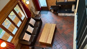 Un intérieur chaleureux avec un banc en bois, un canapé et une table à manger.