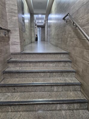 A set of stone steps leading up to a door with a bicycle parked nearby.