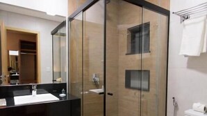 A modern bathroom with a glass-enclosed shower, a black countertop sink, and a white toilet. - Adria Premium Hotel (Guarapuava)
