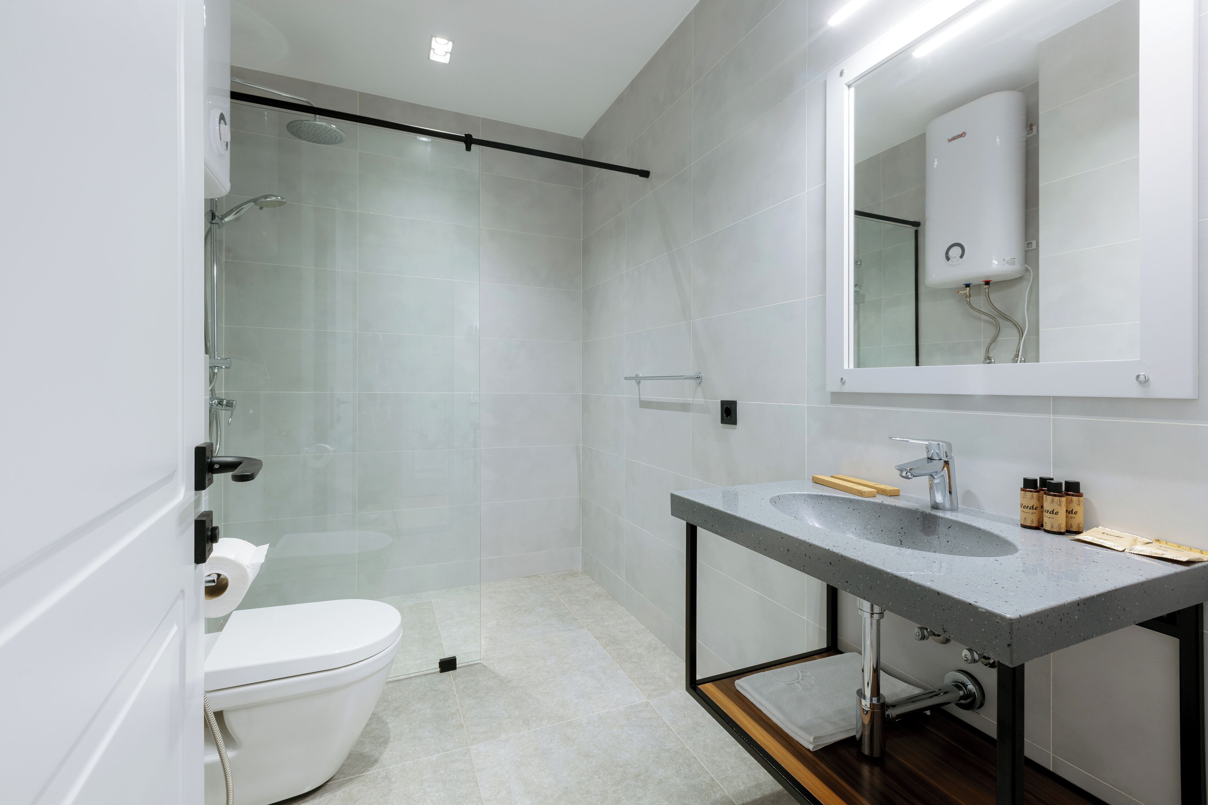 A modern bathroom with a toilet, sink, and shower.