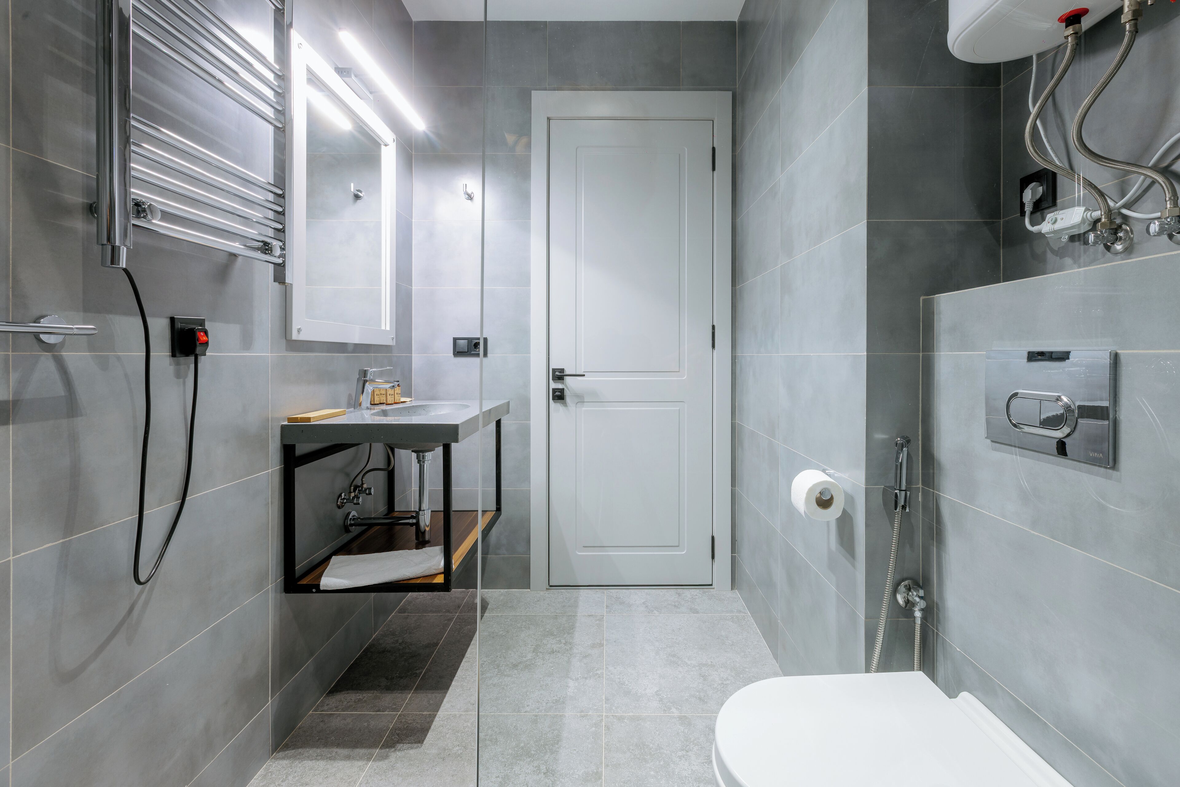 Un baño moderno con inodoro, lavamanos y ducha.