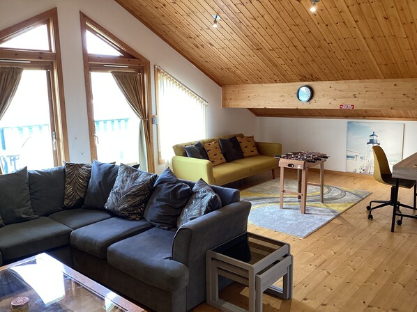 A cozy living room with a grey sofa, a yellow armchair, and a wooden ceiling. - Honeypot Lodge
Scandinavian Style, on-site golf course. (Fritton)