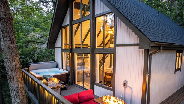 Una terraza de madera con un sofá rojo y un brasero.