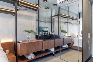 Ein modernes Badezimmer mit einem Holzkosmetikschrank, zwei Waschbecken, einem großen Spiegel und einer Duschkabine aus Glas.