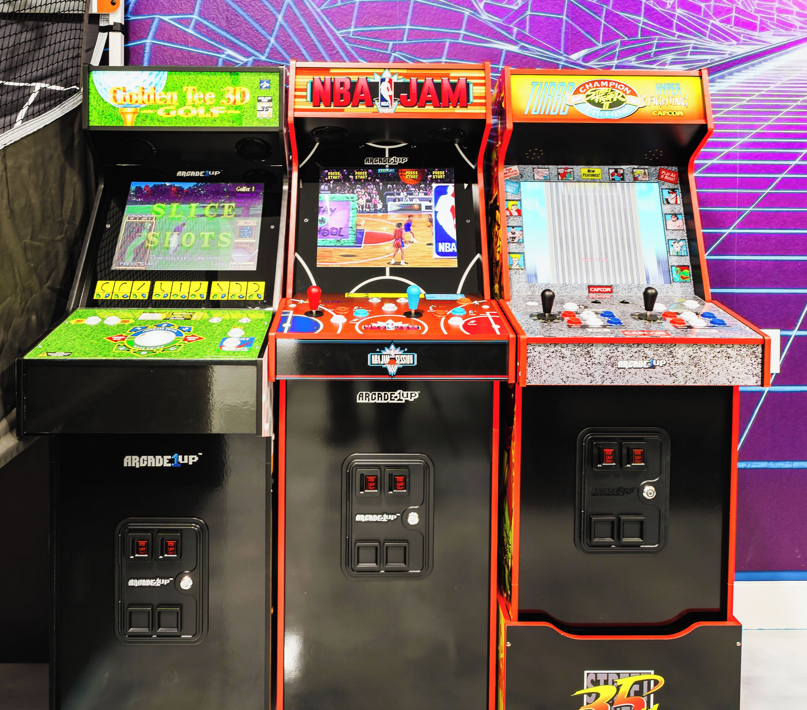 Three arcade machines with different games, including NBA JAM and Turbo Champion.
