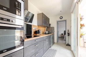 Una cucina moderna con forno, microonde e macchina del caffè.