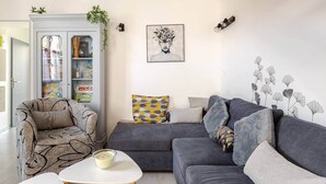 A living room with a grey sofa, patterned armchair, and a white coffee table. - "Chez Céline et Frédéric" : house n°1 / T3 60m2 (Rochefort)