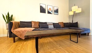 A modern living room with a sectional sofa, a coffee table, and a floor lamp.