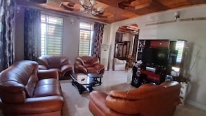 Un salón con sofás de cuero, una mesa de centro y una televisión.