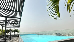 A rooftop pool with a wooden deck and a metal pergola. - Easy Stay at the Lennox  (Accra)