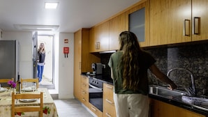 Una cocina moderna con armarios de madera, horno integrado y un ventanal grande.