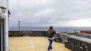 Una persona de pie en un balcón con vistas a la costa.