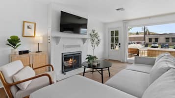 Smart TV, lareira, livros, aparelho de som