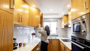 Une cuisine moderne avec des meubles en bois, des appareils électroménagers en acier inoxydable et une grande fenêtre.
