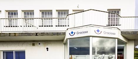 Een gebouw met een balkon en een bord waarop 'Graciosa' staat.