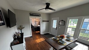 Une cuisine spacieuse avec un coin repas, un plancher en bois, un ventilateur de plafond et une vue dégagée grâce à de grandes fenêtres.