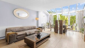 Una sala de estar moderna con un sofá, una mesa de centro y un ventanal con vistas a zonas verdes.