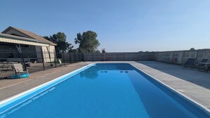 A rectangular swimming pool with a metal ladder in the foreground. - Wichita's Spring Lake RV Resort (Halstead)