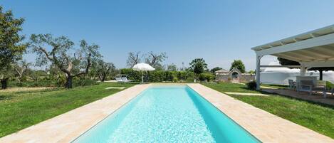 Una piscina al aire libre de temporada, sombrillas