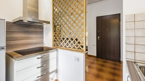 Een moderne keuken met een roestvrijstalen afzuigkap, een houten aanrecht en een wit kastje met lades.
