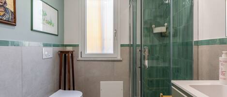 Une salle de bain moderne équipée de toilettes, d’un lavabo et d’une douche à parois en verre.