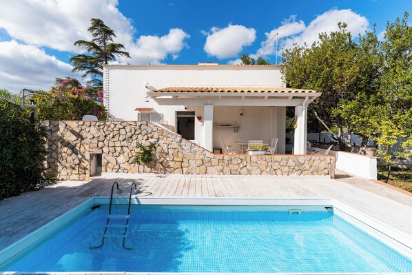 Piscine extérieure en saison, chaises longues