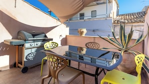 An outdoor patio with a glass table, chairs, a barbecue grill, and a potted plant. - Nicu Amuri con Terrazza a Noto by Wonderful Italy (Noto)