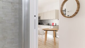 Une cuisine moderne avec des meubles blancs, un four à micro-ondes et une machine à café.