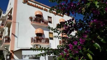 Un edificio de varios pisos con balcones, un letrero que dice 'Seminario de la Rioja' y algunas plantas con flores al frente.