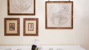 A room with a white table displaying a world map, framed maps, and a coffee setup. - Duomo Center Apartment 2 (Milano)