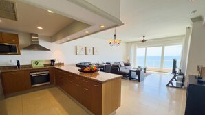 A modern kitchen with a central island, built-in oven, microwave, and stainless steel range hood.
