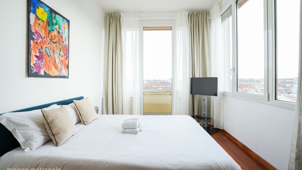 A hotel room with a bed, a TV, and a painting on the wall. - Torino Centro | Bertola House (Turin)