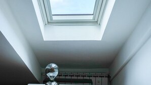 A skylight in a room with white walls and a visible ceiling structure. - Torino Centro | Bertola House (Turin)