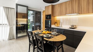 Een moderne keuken met houten kastjes, een centraal eiland en een eethoek met een ronde tafel en stoelen.