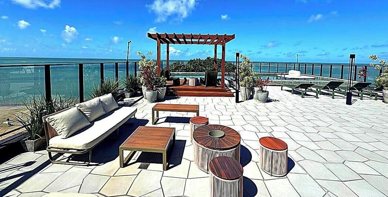 An outdoor patio with seating, a pergola, and potted plants.