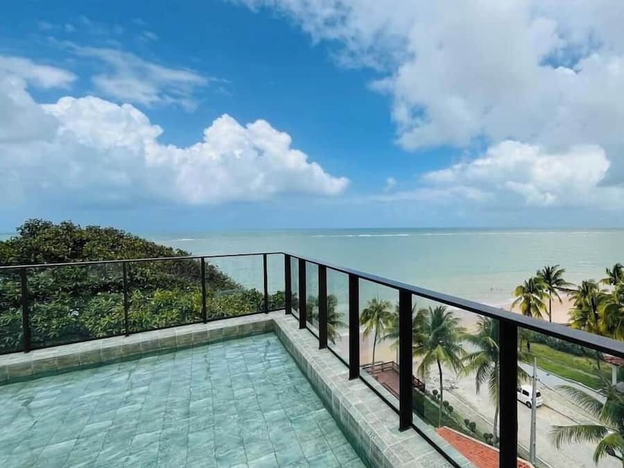 Una piscina amb vista a l'oceà i palmeres.
