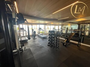 Ein Fitnessstudio mit Trainingsgeräten, Laufbändern und Gewichtsständern.